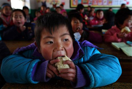 2月23日，宁夏固原市西吉县西滩乡。西滩中心小学一年级一班的马燕正在吃从家带的馒头。牛光 摄